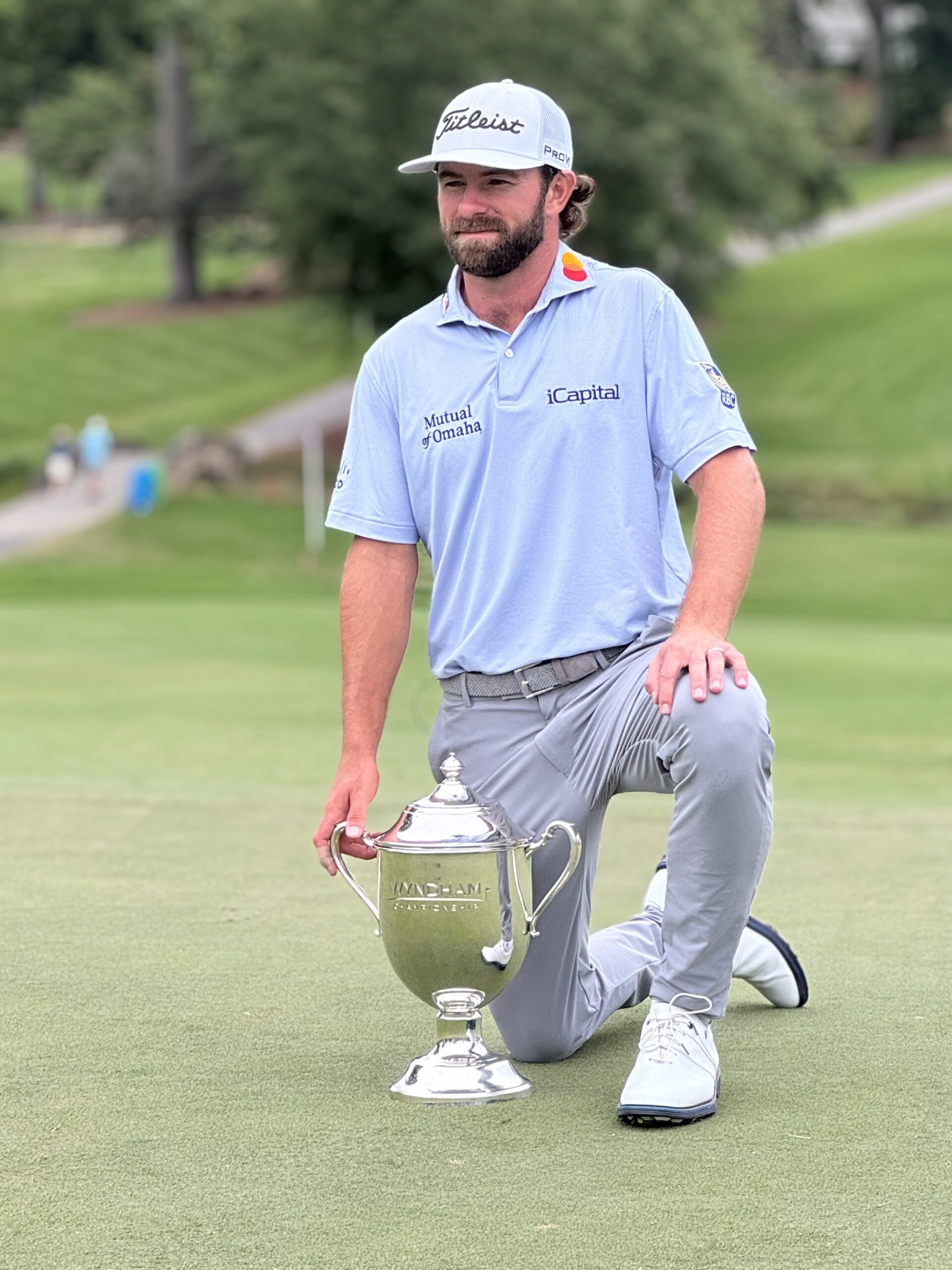 Cameron Young celebrates his first PGA TOUR victory at the Wyndham Championship, proudly holding the trophy after a record-tying 22-under-par performance — proudly sponsored by iCapital.